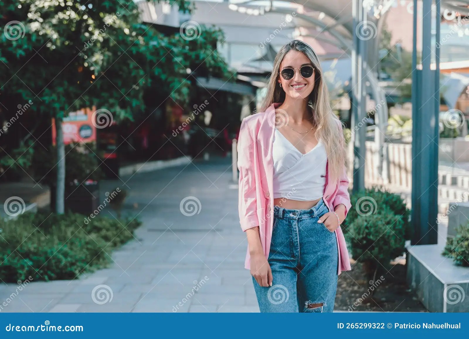 Empowered Young Woman Smiling and Standing on a Sidewalk. Feminine