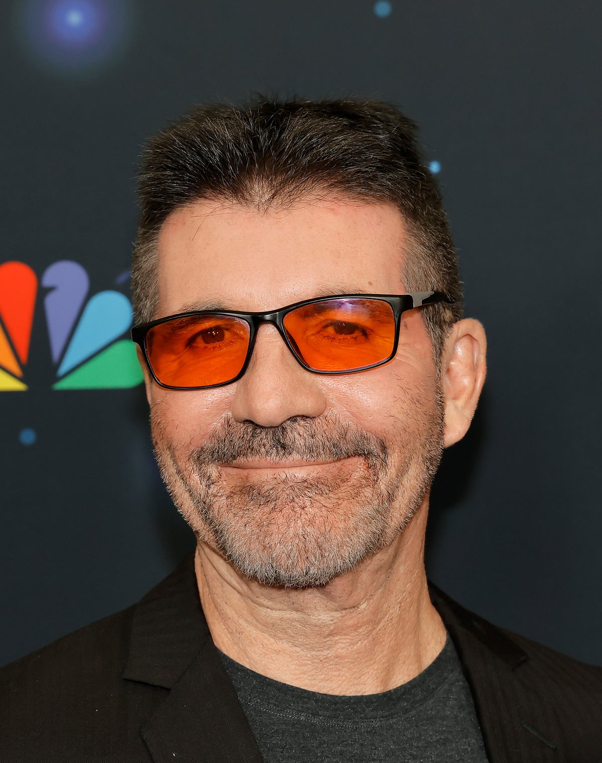 Why does Simon Cowell wear redtinted glasses?